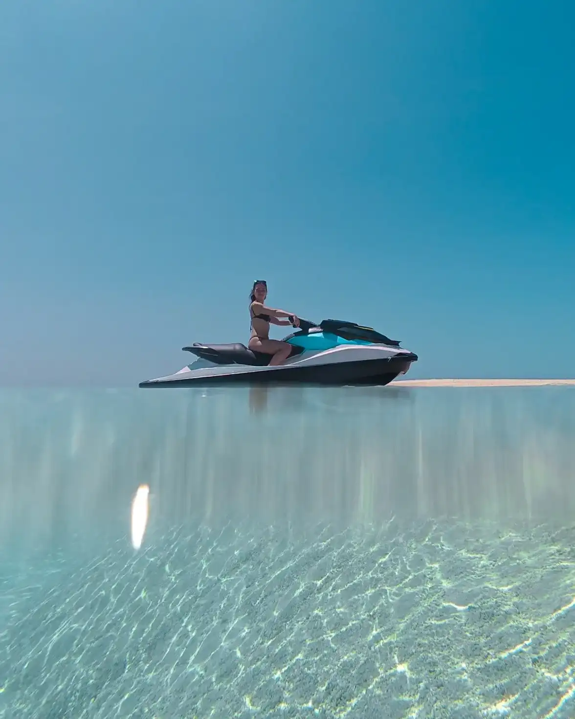 Rider on a jet ski over glassy turquoise water