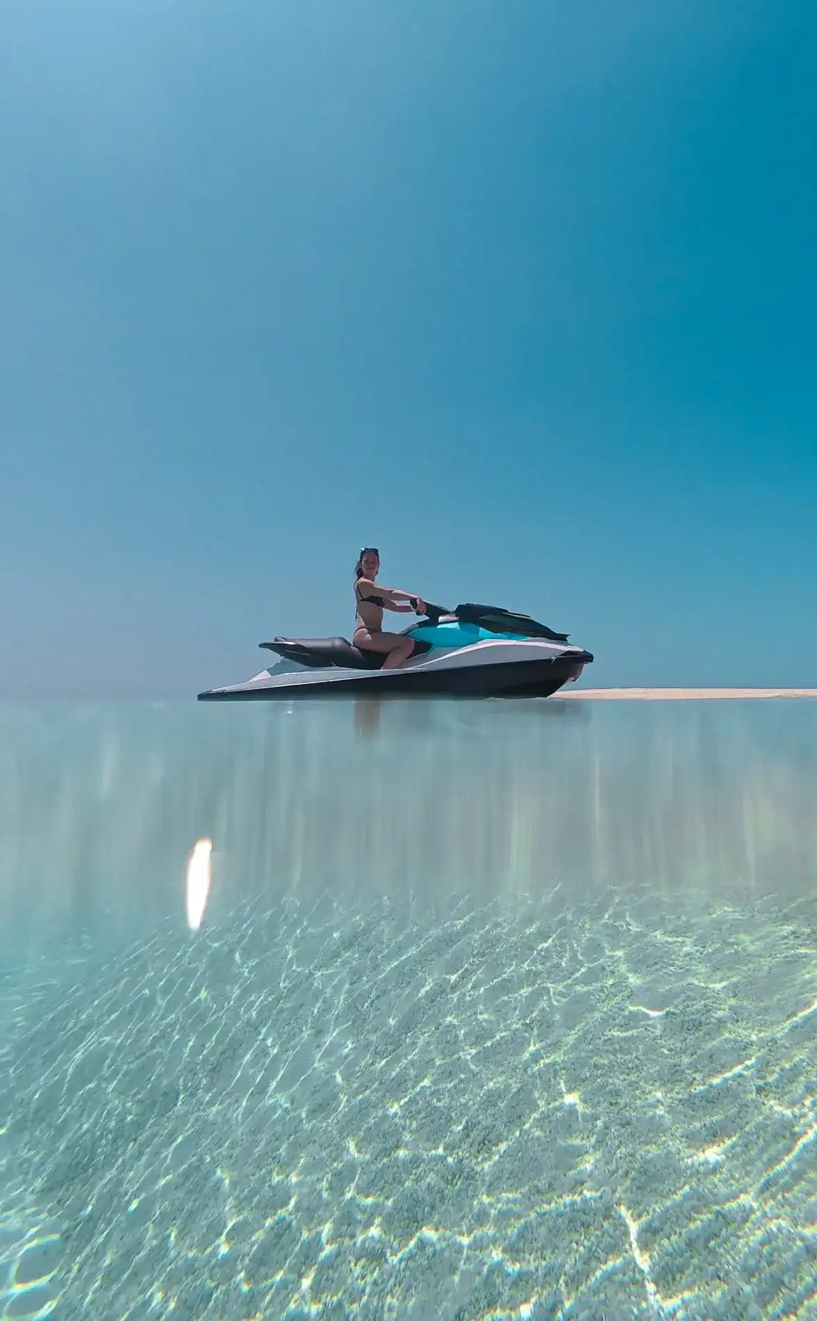 Rider on a jet ski over glassy turquoise water